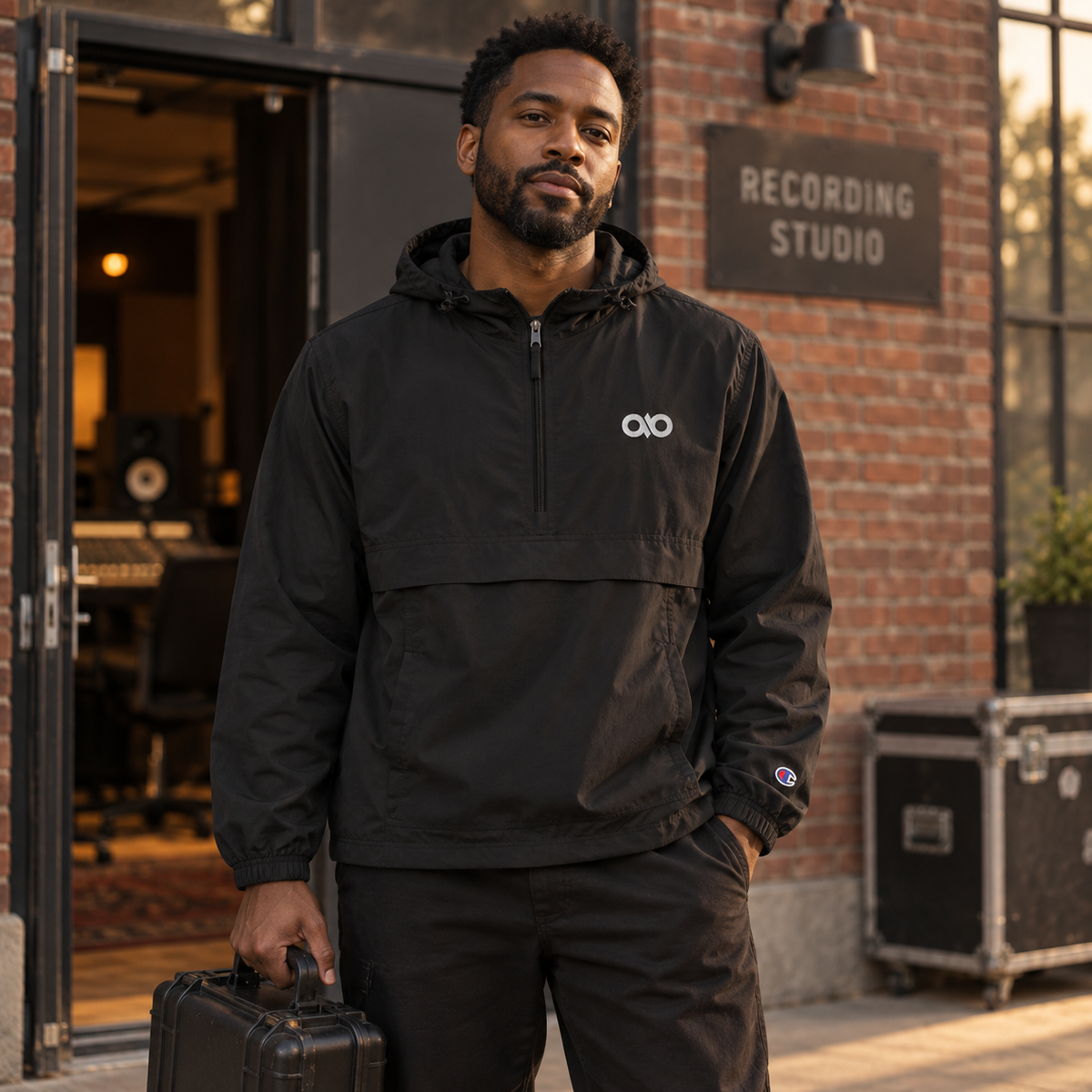 Creative professional wearing the black IO Champion packable anorak