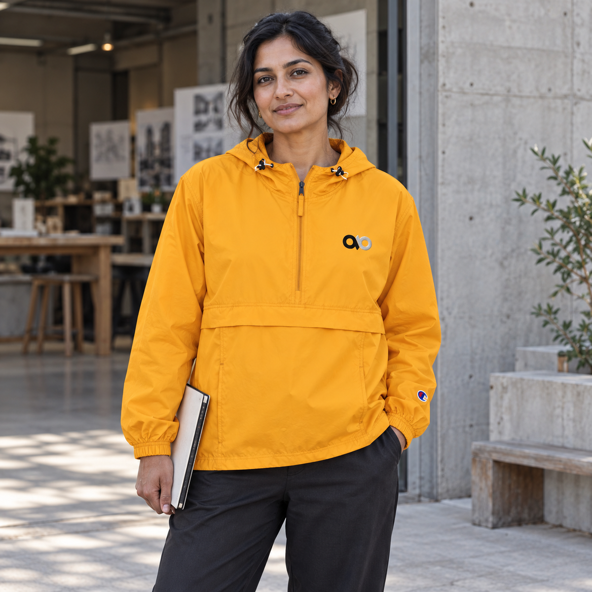 Creative professional wearing the gold IO Champion packable anorak