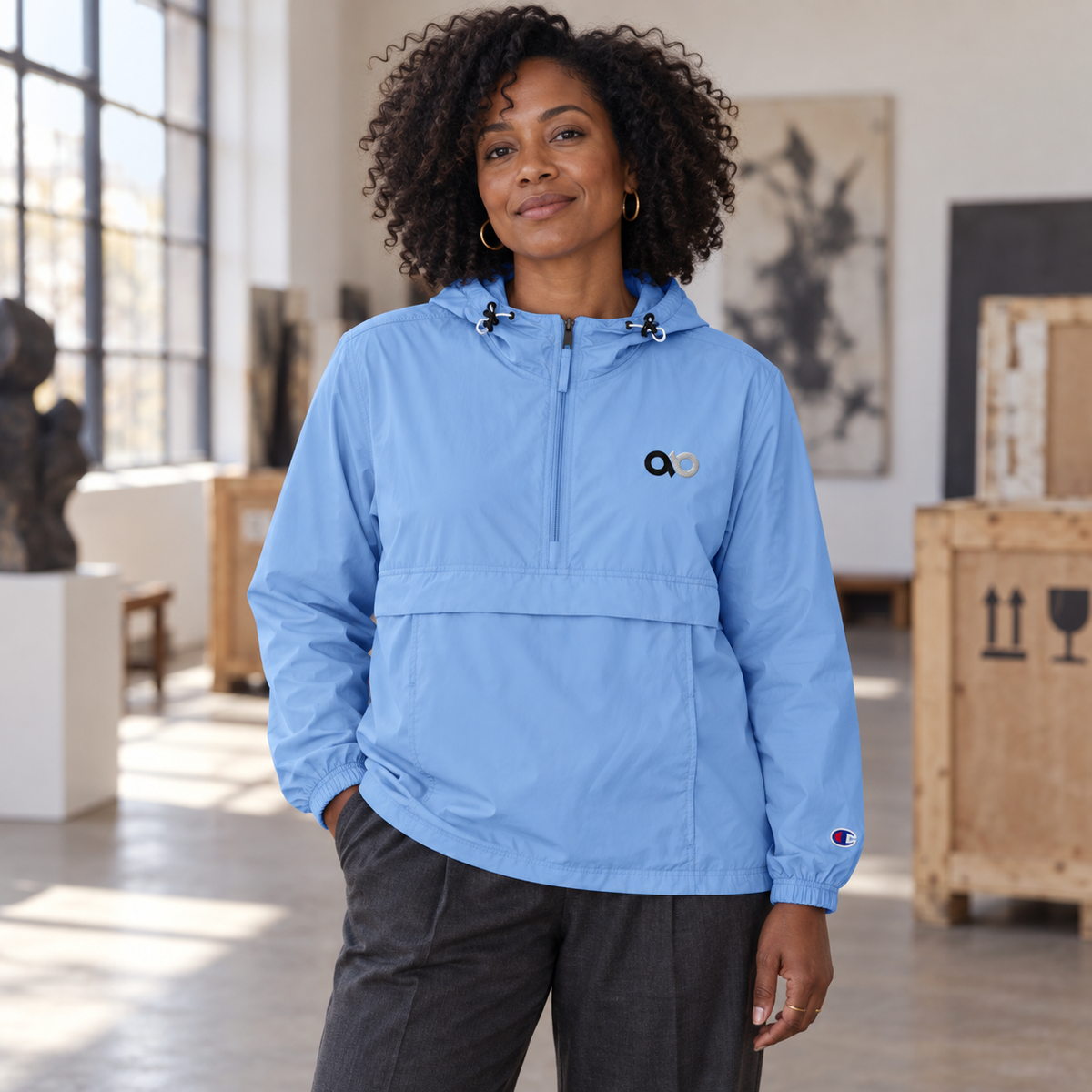 Creative professional wearing the light blue IO Champion packable anorak
